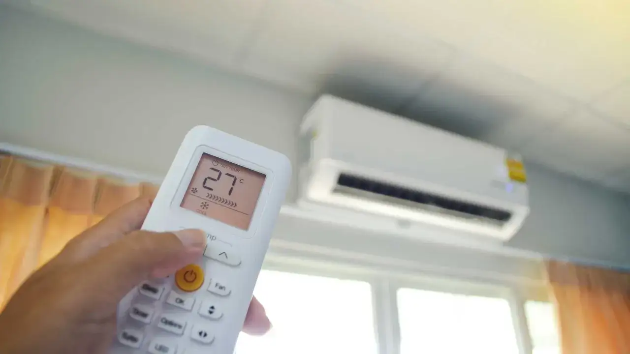 Pilot klimatyzatora ustawia temperaturę 27°C. Urządzenie zapewnia komfortowe ogrzewanie i chłodzenie.