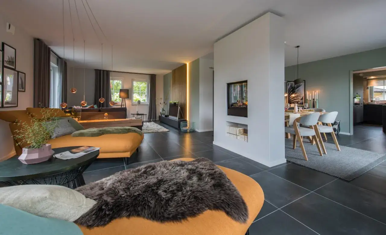 Modernes Wohnzimmer mit orangefarbenem Sofa, Kamin und Essbereich. Ein sch&ouml;nes Beispiel, wie man ein Haus einrichten kann.