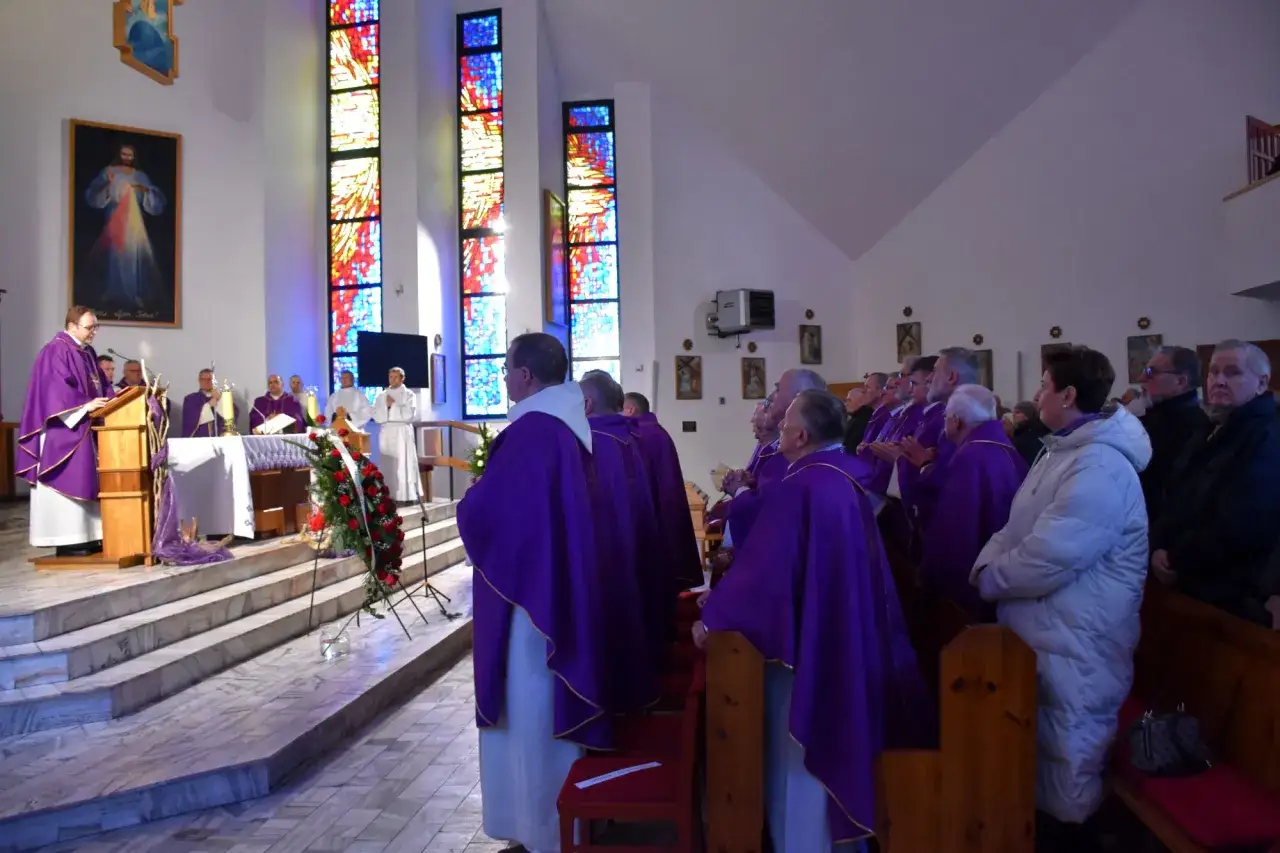 Uroczystość pogrzebowa w kościele. Duchowni w purpurowych szatach, pytanie