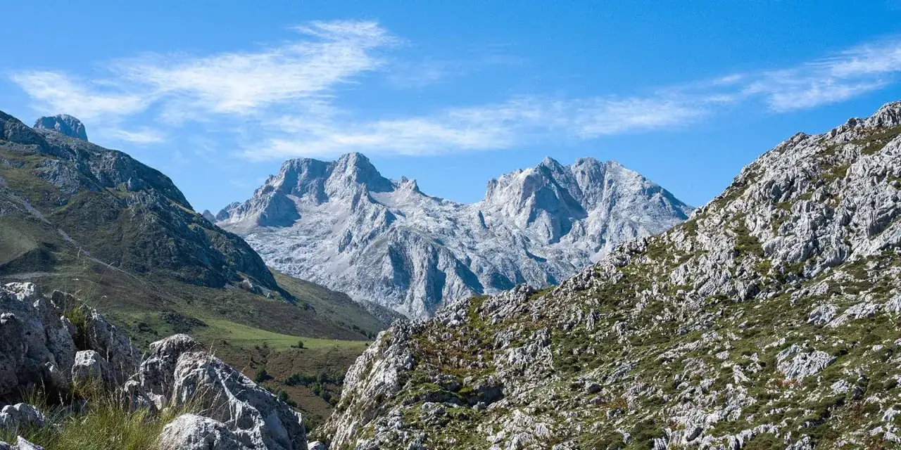 Majest&auml;tische Berge bei Lagos de Covadonga unter blauem Himmel mit leichten Wolken. Felsige H&auml;nge mit gr&uuml;ner Vegetation.