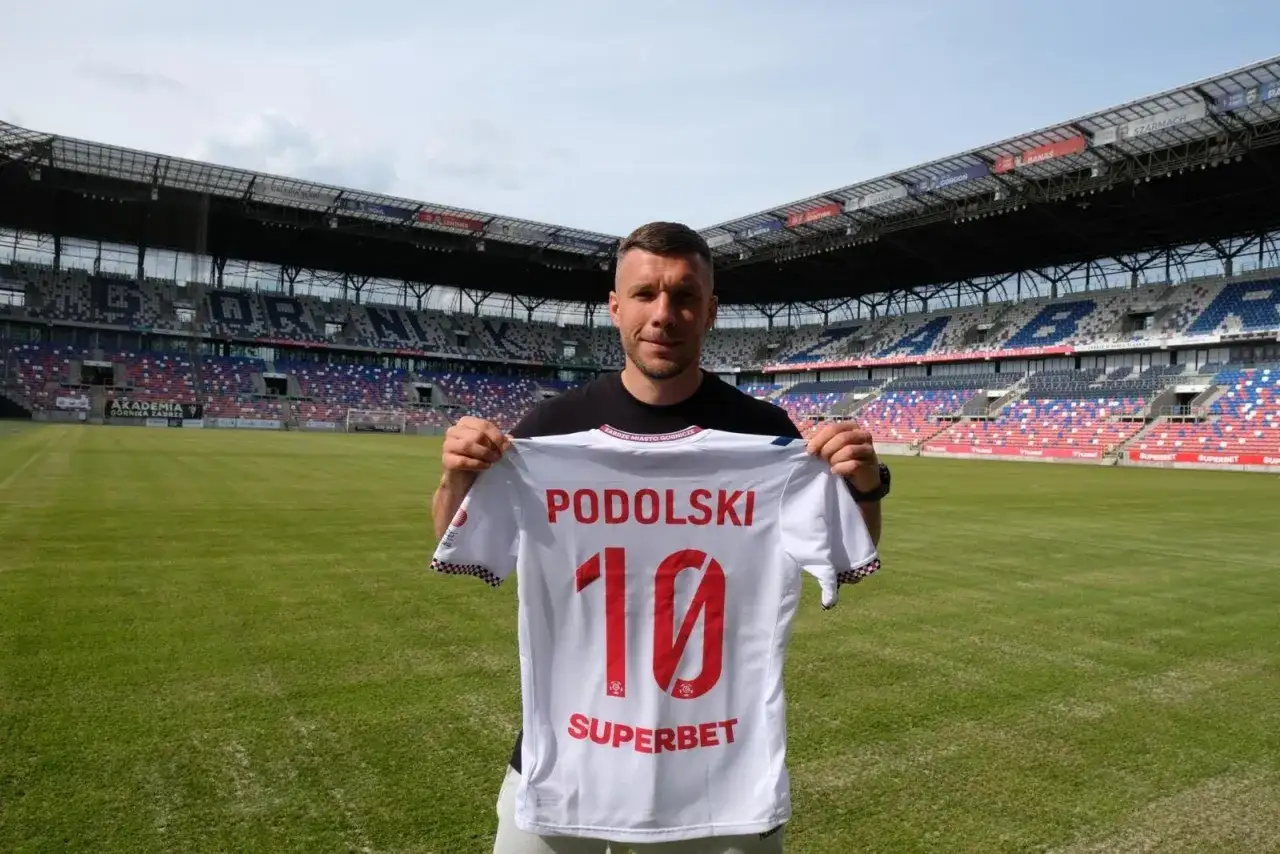Piłkarz Lukas Podolski prezentuje koszulkę z numerem 10. Jego statystyki w karierze są imponujące.