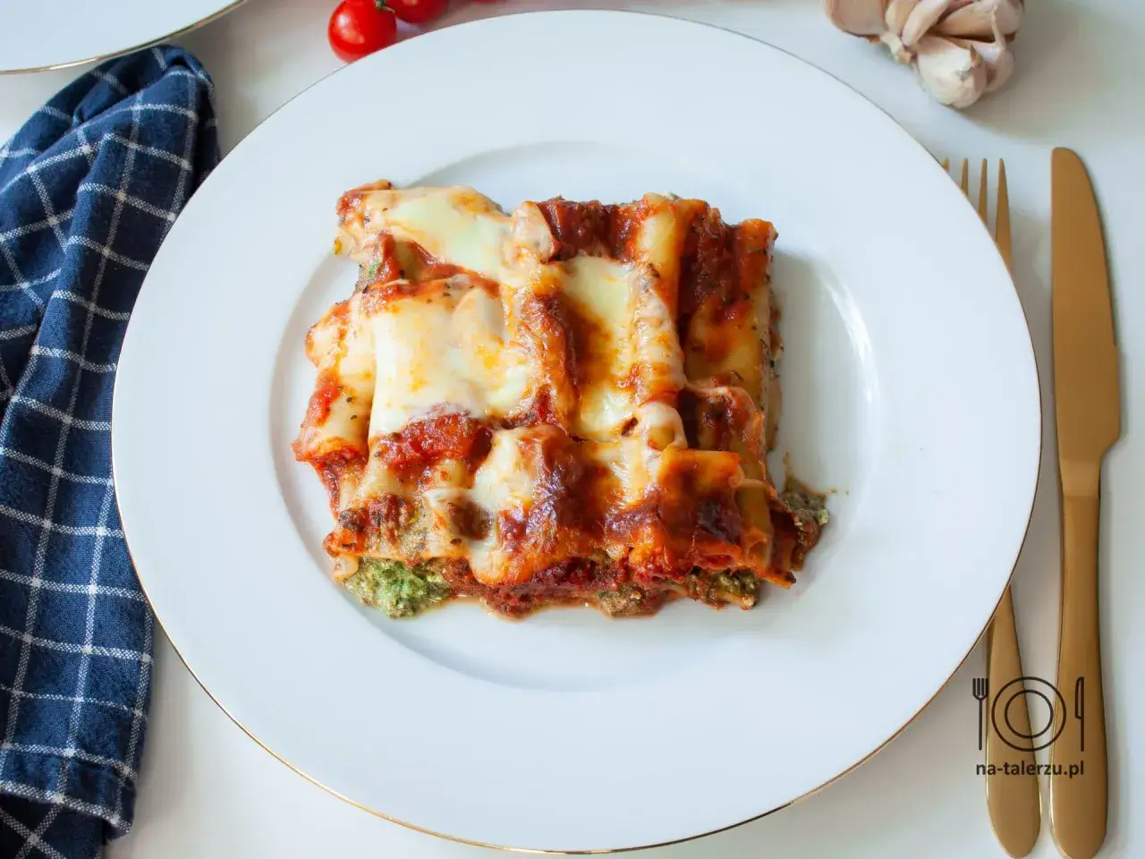 Pyszne cannelloni ze szpinakiem, zapieczone pod sosem pomidorowym i ciągnącym się serem. Idealne danie na obiad.
