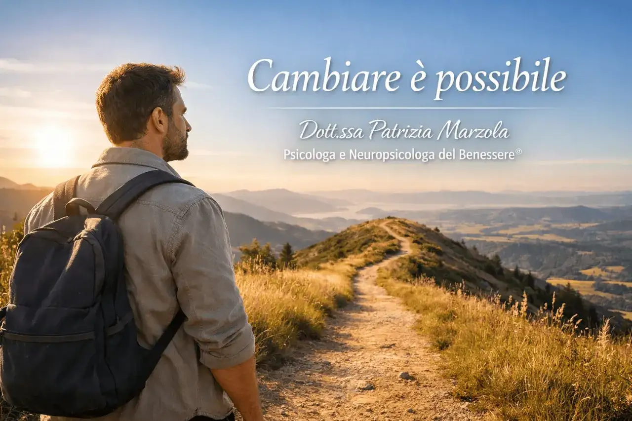 Uomo con zaino guarda un sentiero in montagna al tramonto.