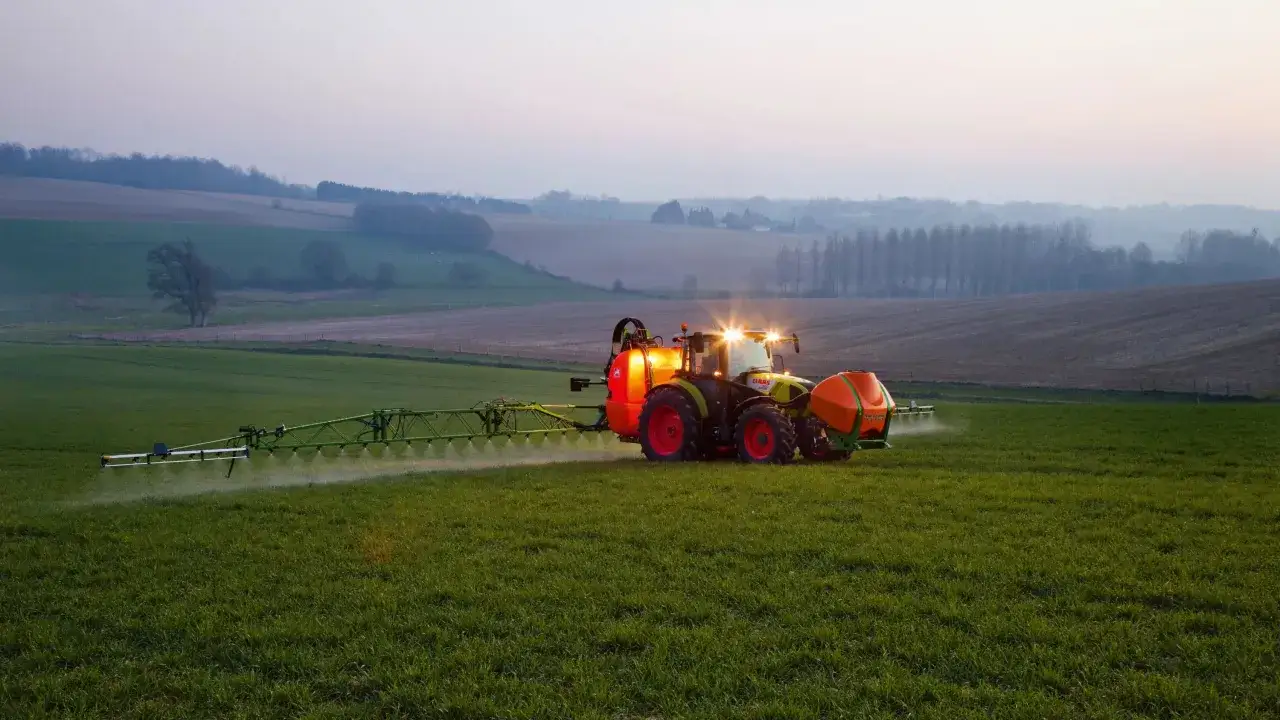 Traktor opryskuje pole, pokazując, jak stosować roundup.