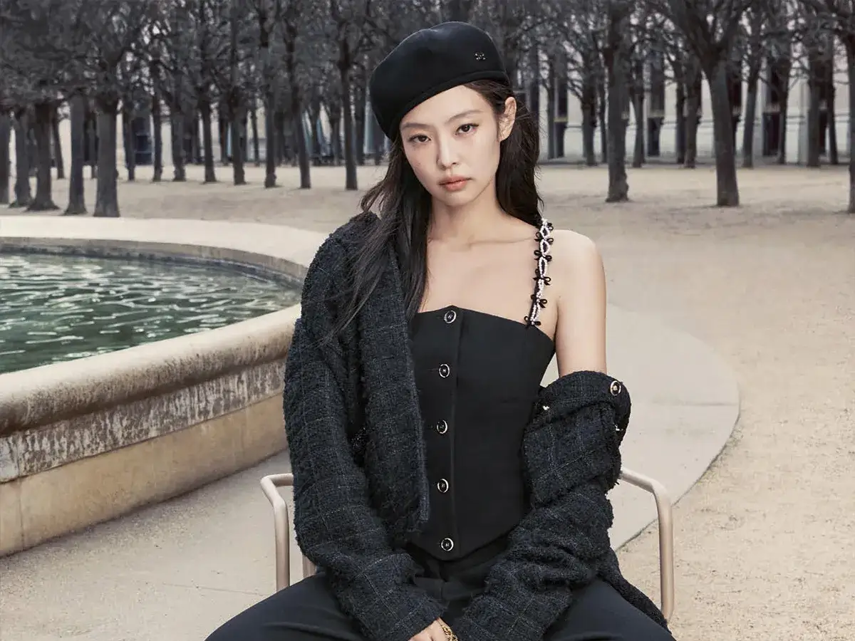 Jennie stars in a chic Chanel campaign, posing elegantly in a black beret and tweed jacket by a fountain.