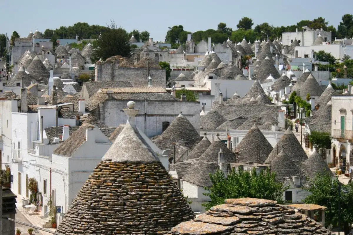 En vy över de unika trullihusen i Alberobello, Italien. Dessa konformade tak skapar en sagolik silhuett mot himlen.