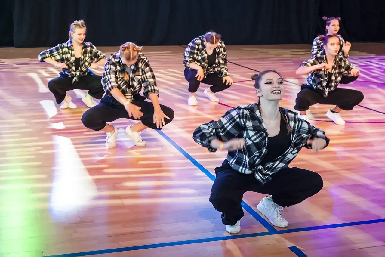 Tancerki w kratę podkreślają rytm, każdy ruch to akcent w muzyce.