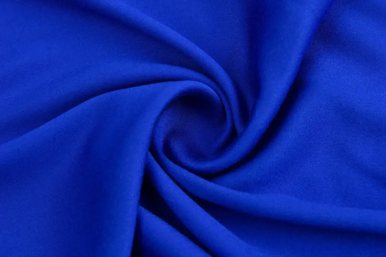 A swirl of vibrant blue fabric, showcasing how viscose is stretchy and drapes beautifully.