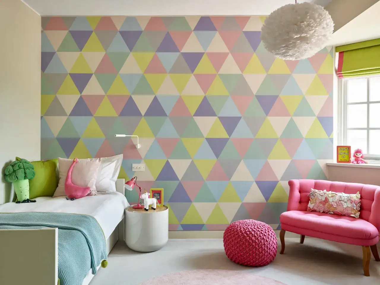 Habitaci&oacute;n juvenil con pared de tri&aacute;ngulos pastel, ideal para pintar habitaci&oacute;n juvenil dos colores. Cama blanca, sill&oacute;n rosa y detalles divertidos.