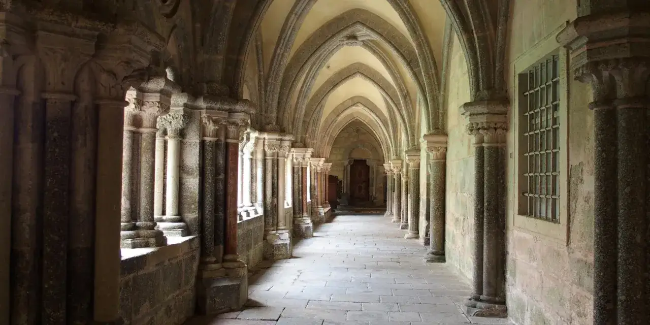 Gotische Säulenhalle im Stift Zwettl mit steinernem Boden und Bogenkonstruktion.
