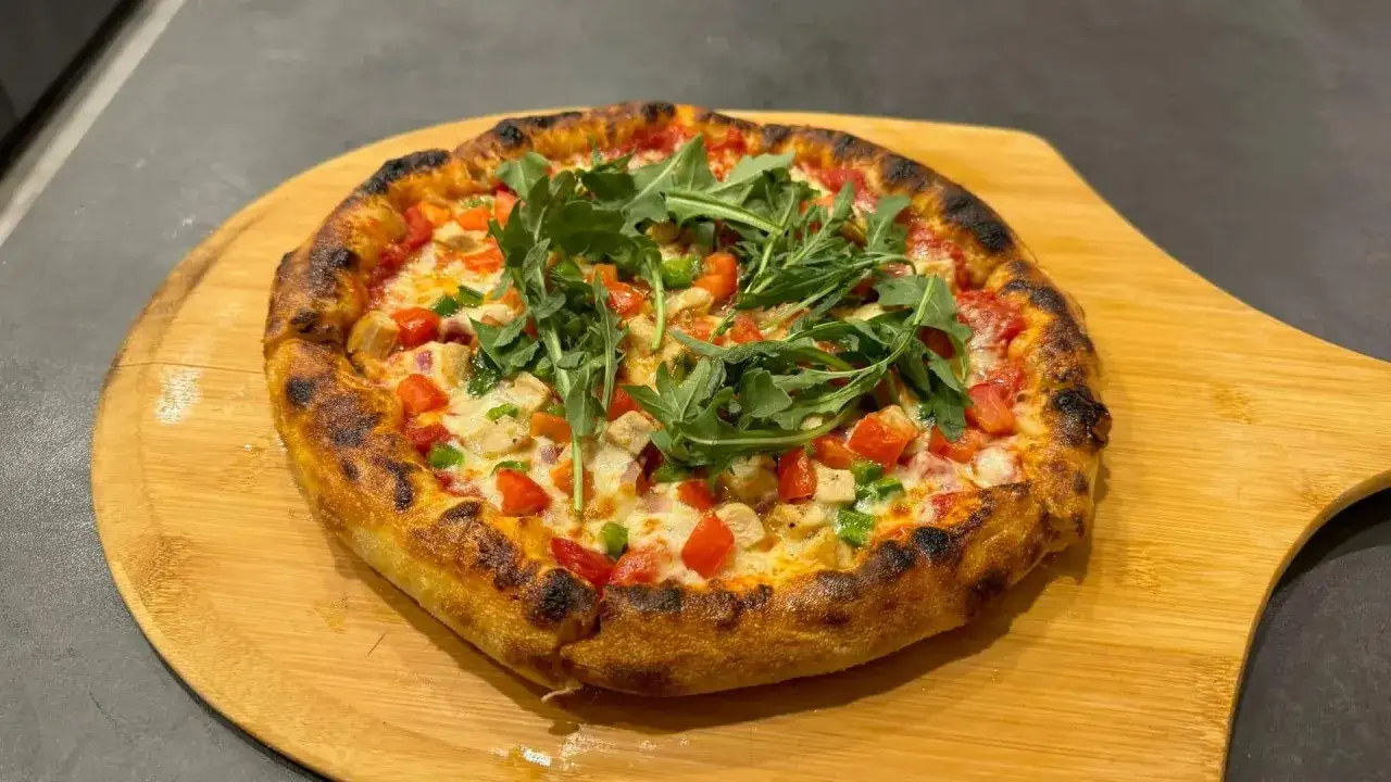 En gyllene, nybakad pizza med kyckling, tomater, paprika och ruccola. En riktigt nyttig pizza som ser fantastisk ut!