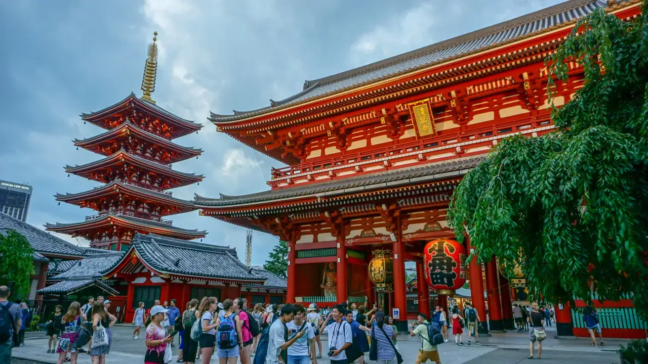 Wielopiętrowa pagoda i czerwona brama świątyni w Japonii. Symbol swastyki w Japonii oznacza szczęście i pomyślność.