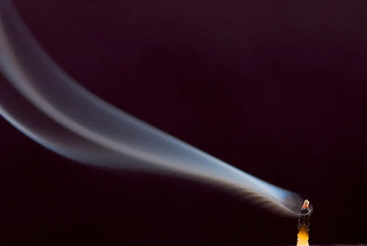 Humo ascendiendo de una vela apagada. Encender velas en casa es malo, puede ser peligroso.