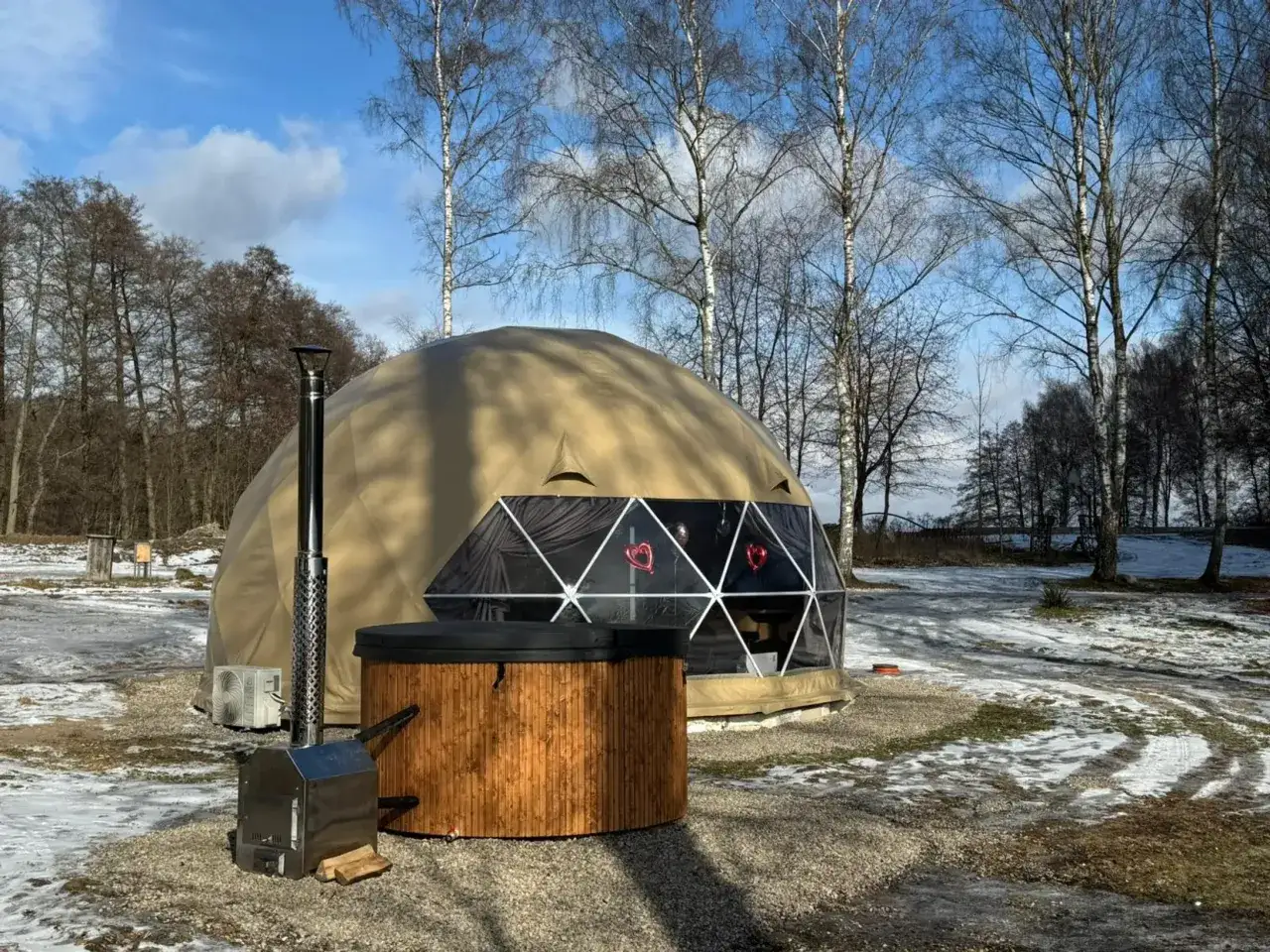 Domek geodezyjny i balia z piecem to idealne miejsce na glamping w Polsce. Zimowy krajobraz dodaje uroku.