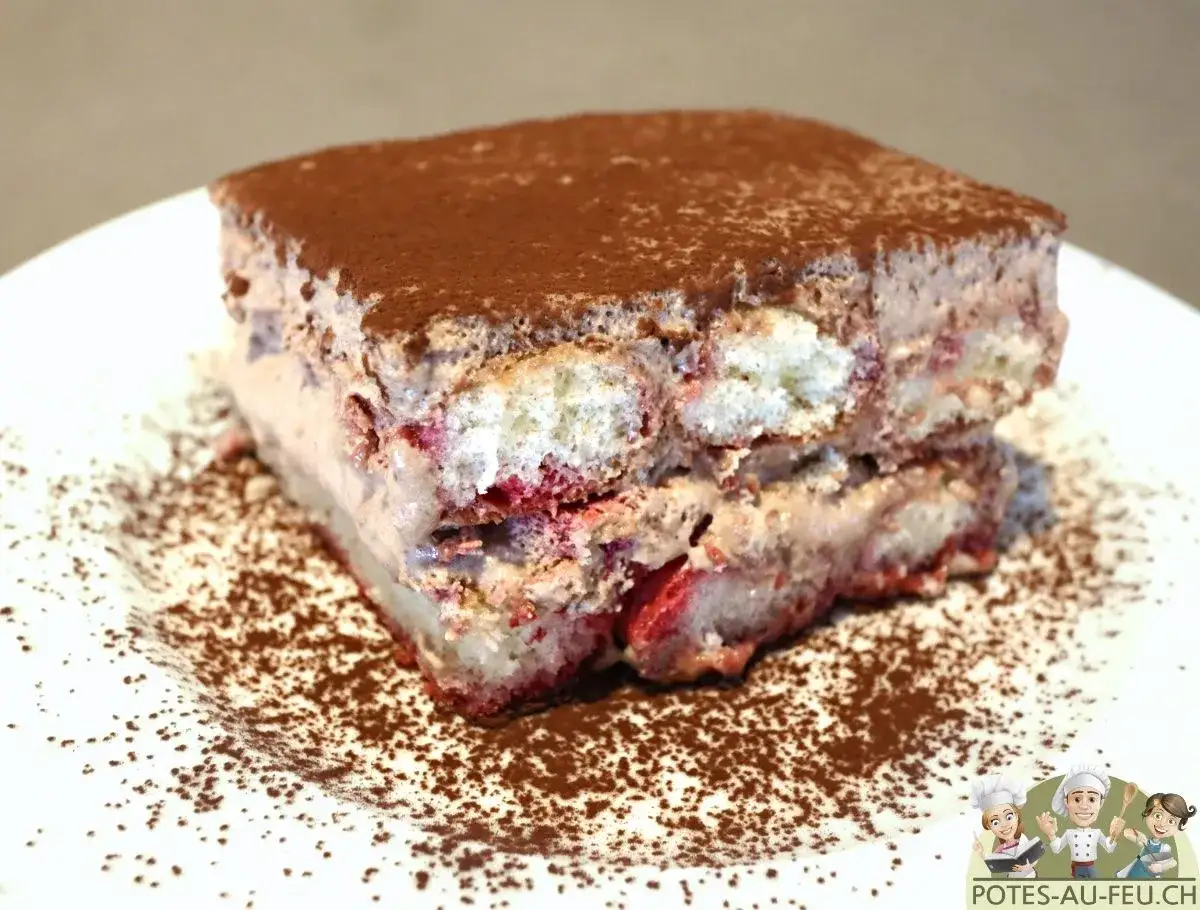 Une part de tiramisu aux fruits rouges, parfaite pour un tiramisu anniversaire. Saupoudré de cacao, il est prêt à être dégusté.