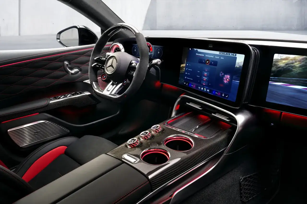 Wnętrze sportowego AMG GT XX z czerwonym ambientowym oświetleniem, ekranem dotykowym i karbonowymi detalami.