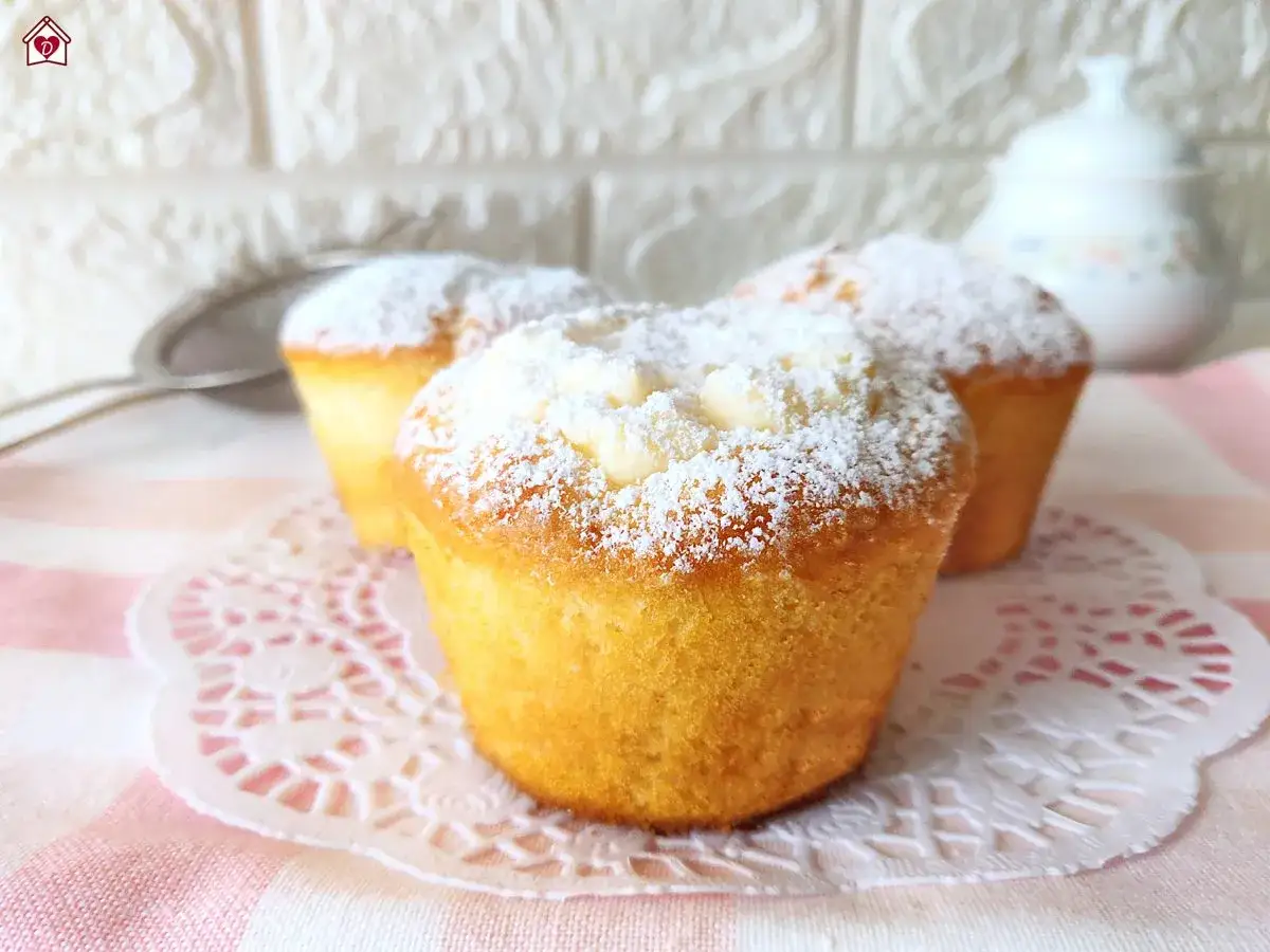 Tre muffin dorati, spolverati di zucchero a velo, perfetti per una ricetta muffin semplici e veloce.