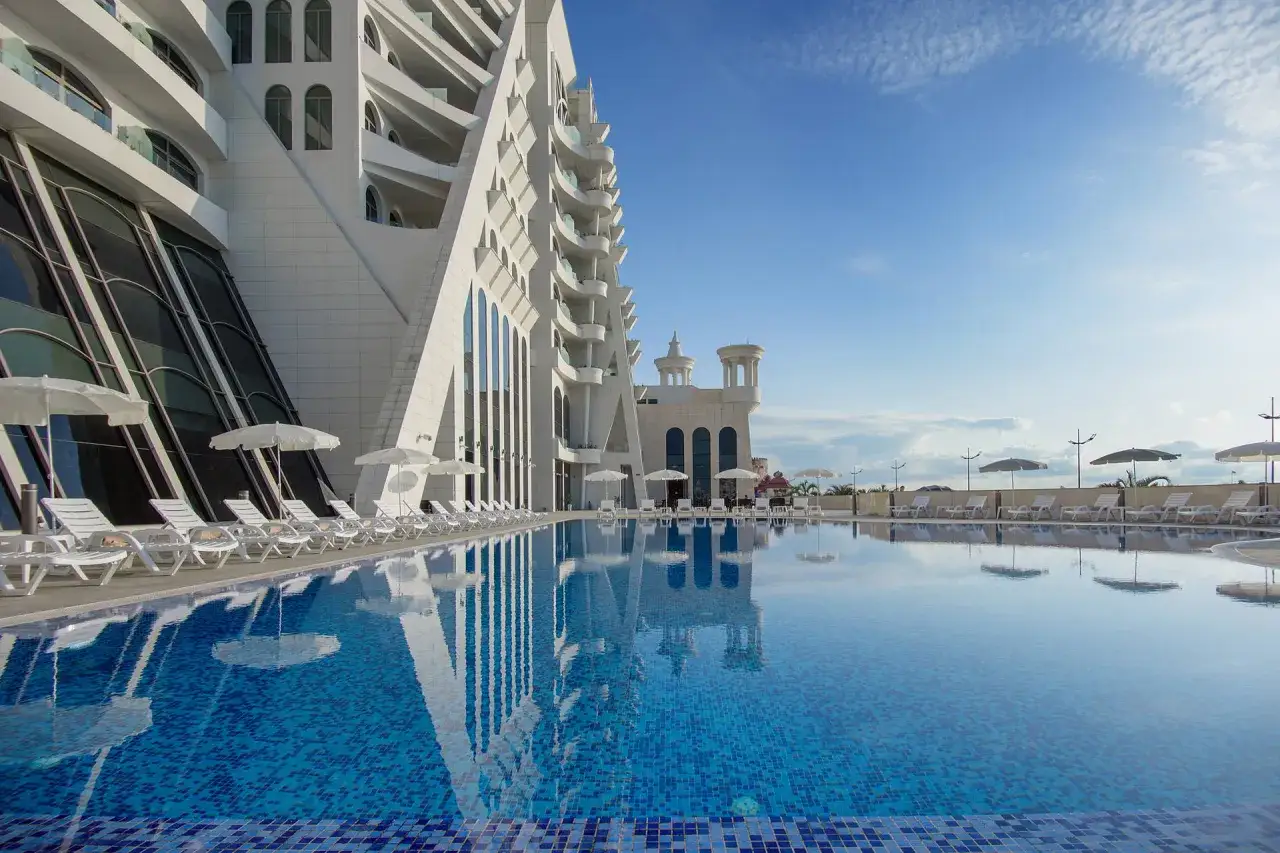 Luksusowy hotel z basenem i leżakami, idealny na wakacje all inclusive w Gruzji.