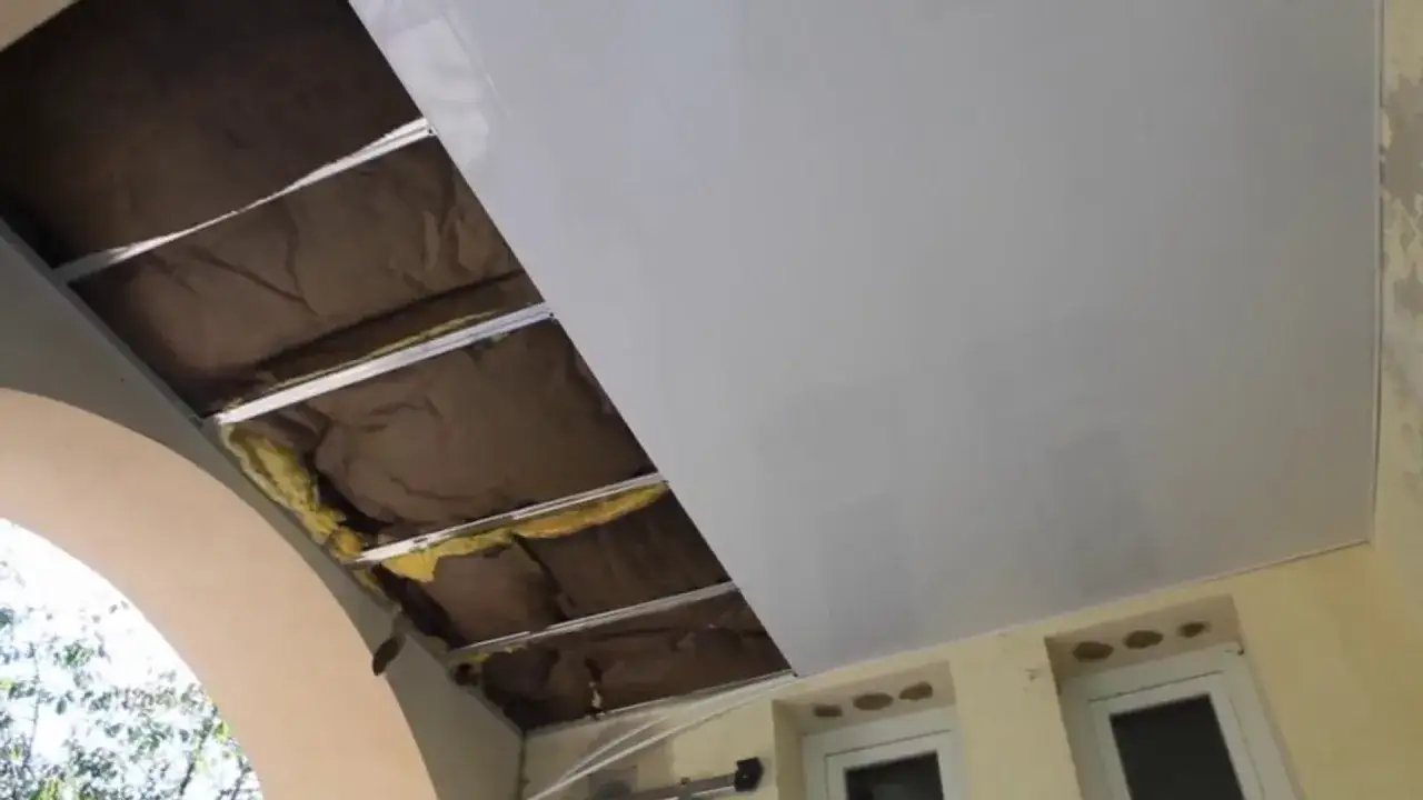 Pose de lambris PVC au plafond, montrant l'isolation et la structure m&eacute;tallique. Le sens de pose est horizontal pour un rendu moderne.