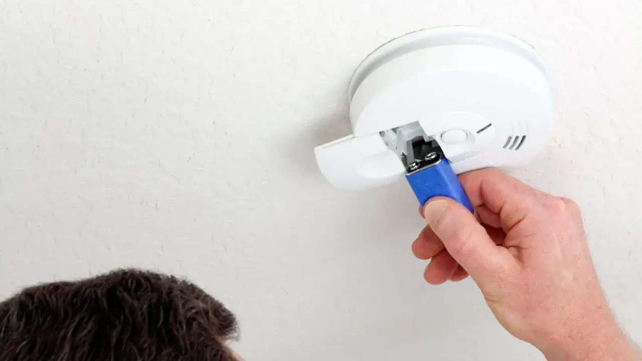 Hand tauscht Batterie im Rauchmelder aus, da die alte rauchmelder batterie leer war. Sicherheit geht vor!