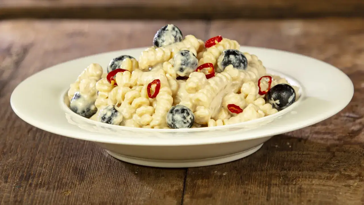 Pasta al tonno in bianco con olive nere e peperoncino, un piatto saporito e invitante.