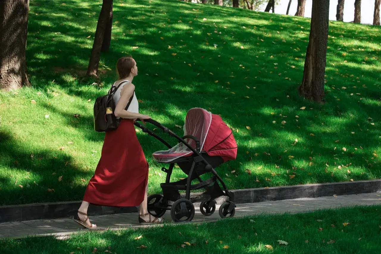 niemowlę w wózku z moskitierą park bezpieczny spacer