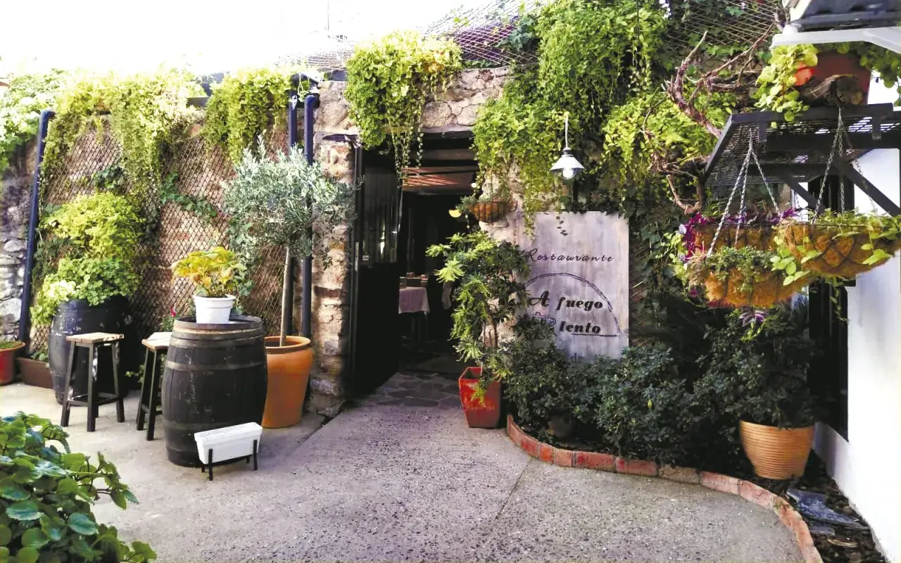 Entrada a un restaurante con mucha vegetaci&oacute;n. Ideal para saber donde comer en Herv&aacute;s.