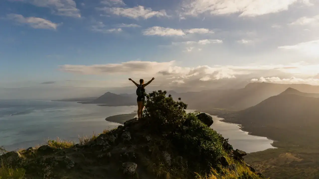 Widok z góry na Mauritius, z turystką z rękami w górze. Czy warto tam pojechać? Tak!