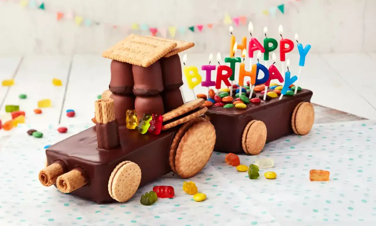 Schokoladen-Traktor-Torte, die man leicht selber machen kann, mit bunten Kerzen und Gummib&auml;rchen verziert.