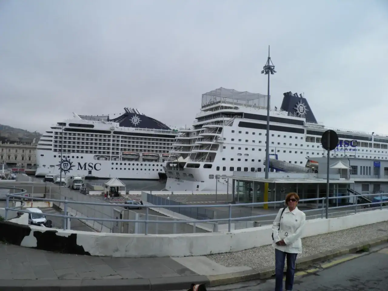 Donna in piedi davanti a due navi MSC in attesa dell'imbarco a Genova per Portofino.