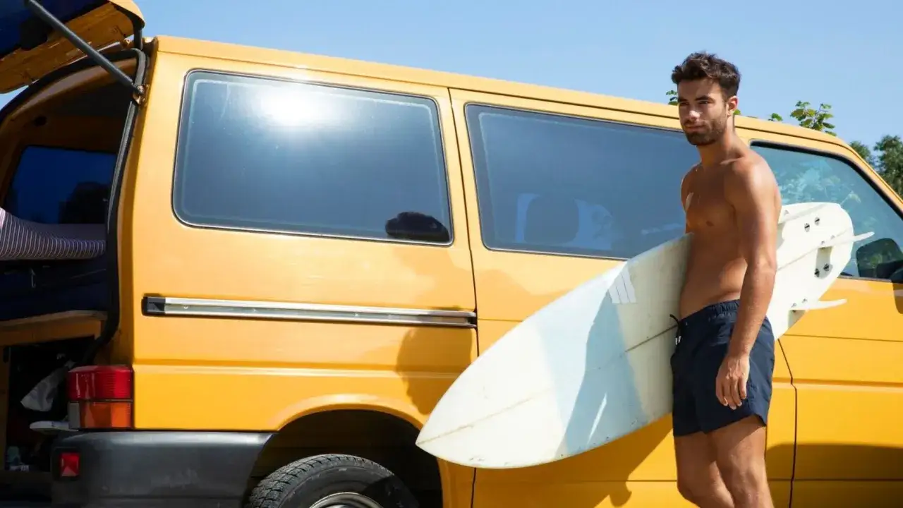 Joven con tabla de surf junto a furgoneta amarilla, listo para su **work and holiday Australia**.
