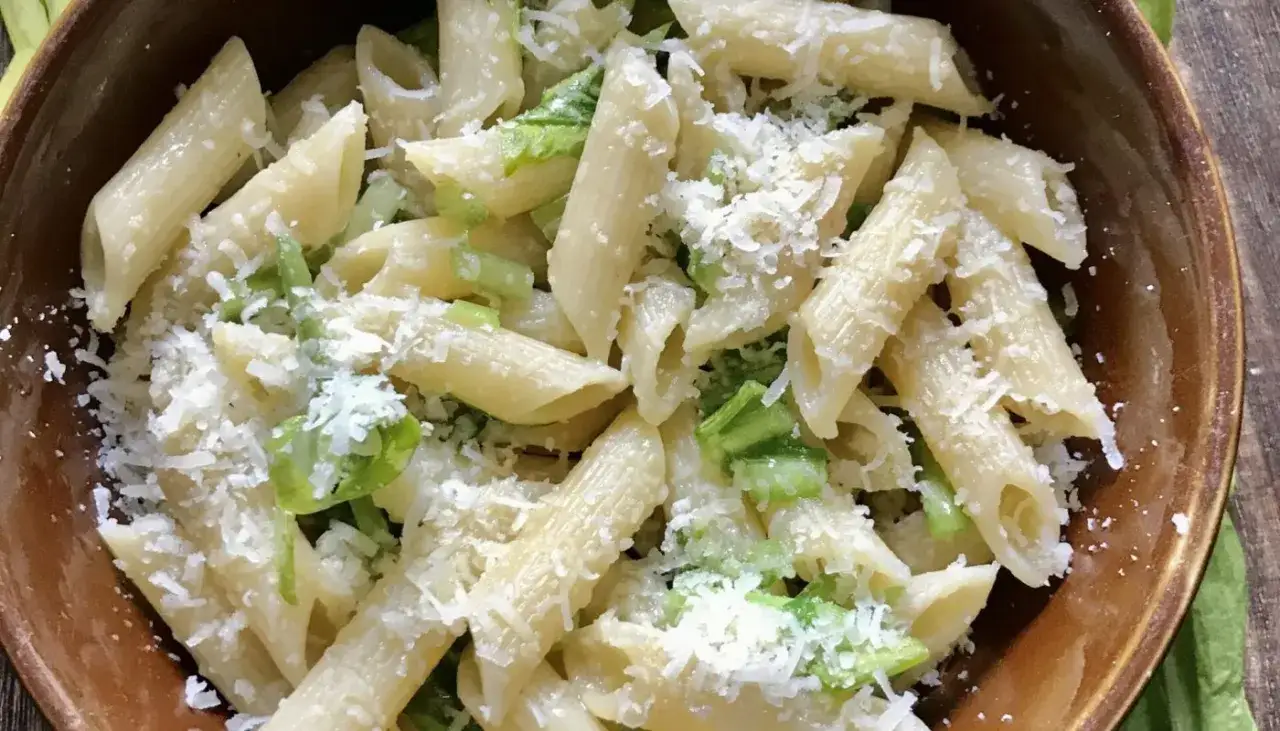 Penne z czosnkiem niedźwiedzim i parmezanem w brązowej misce.