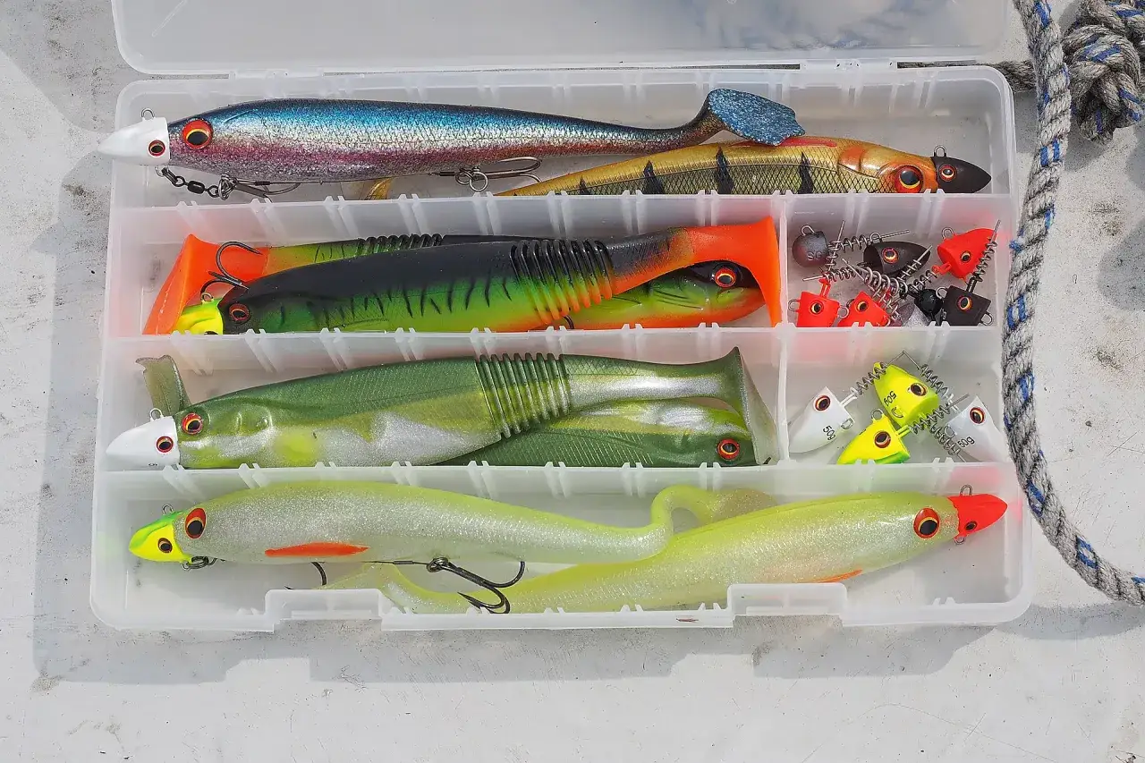 K&ouml;derbox f&uuml;r das Schleppen auf Hecht: bunte Gummifische und Jigs in verschiedenen Gr&ouml;&szlig;en und Farben, bereit f&uuml;r den Fang.