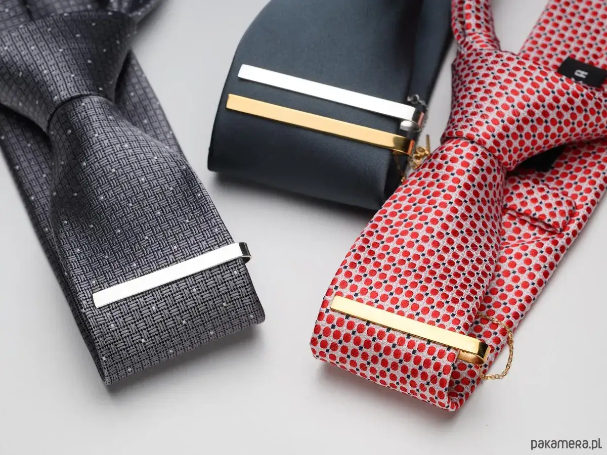 Eleganckie spinki do krawata: srebrna i złota, pokazujące, jak nosić spinkę do krawata, by podkreślić styl.