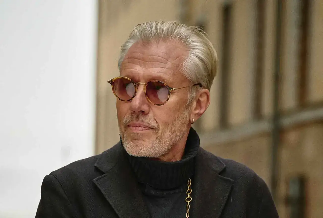 Carl-Johan Vallgren, med sitt gråsprängda hår och trendiga solglasögon, bär en svart polotröja och kavaj. Han ser ut som en konstnärlig själ, kanske en författare som Carl-Johan Vallgren barn inspirerar.