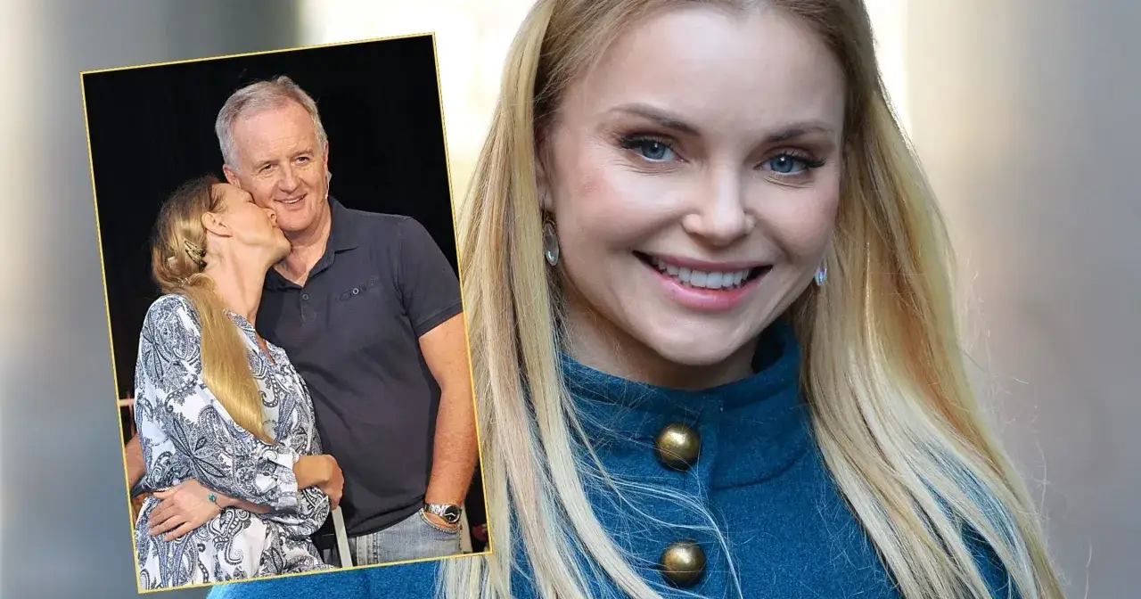 Aleksander Mikołajczak i jego żony. Uśmiechnięta blondynka całuje mężczyznę w policzek.