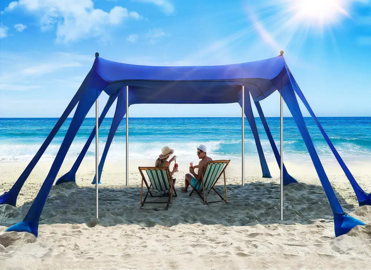 Coppia rilassata sotto una tenda blu in spiaggia, con cocktail in mano. Chiss&agrave; se posso andare al mare se prendo l'antibiotico?