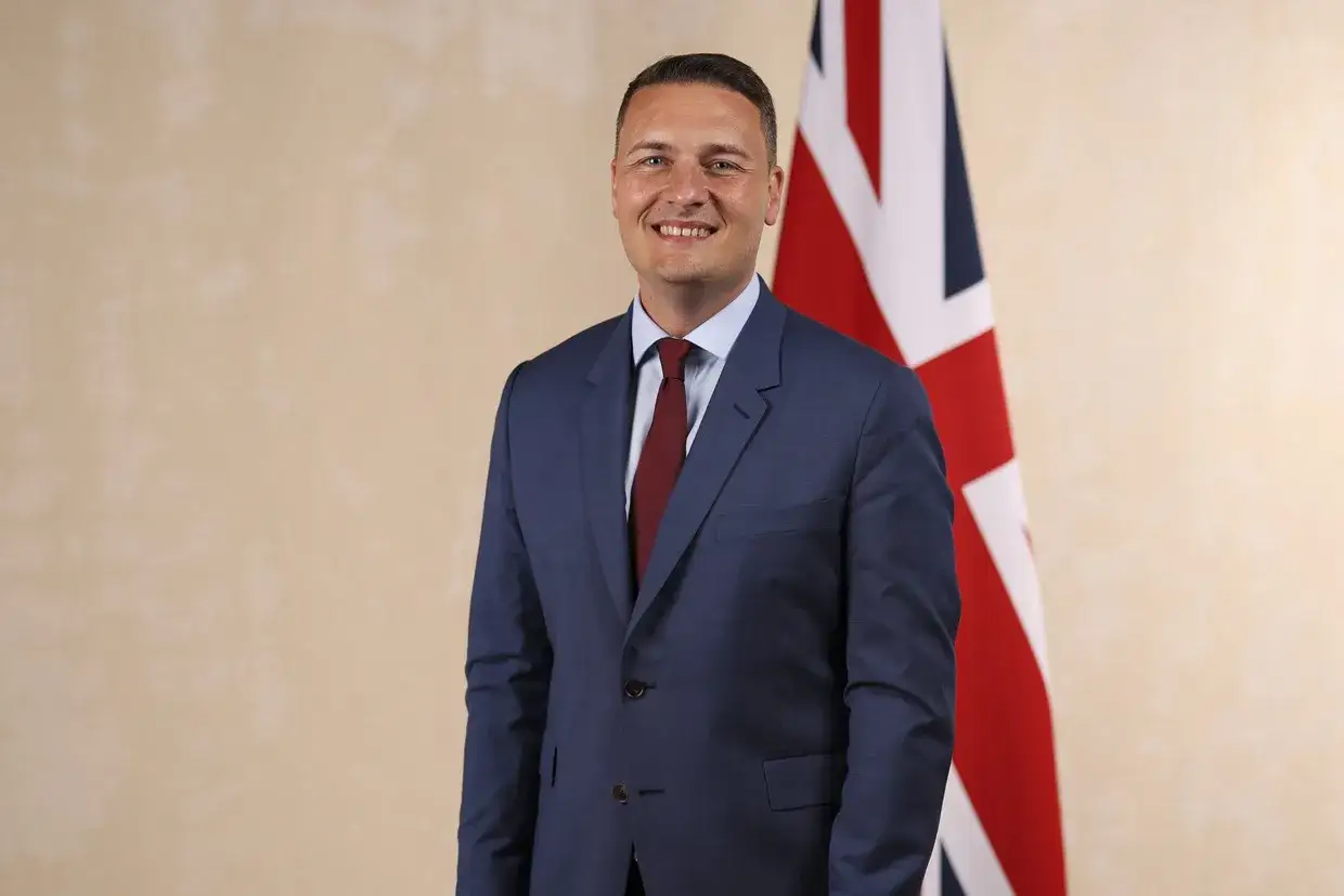 A man in a suit stands before the Union Jack flag, a symbol of how public administration is important for national governance and public service.