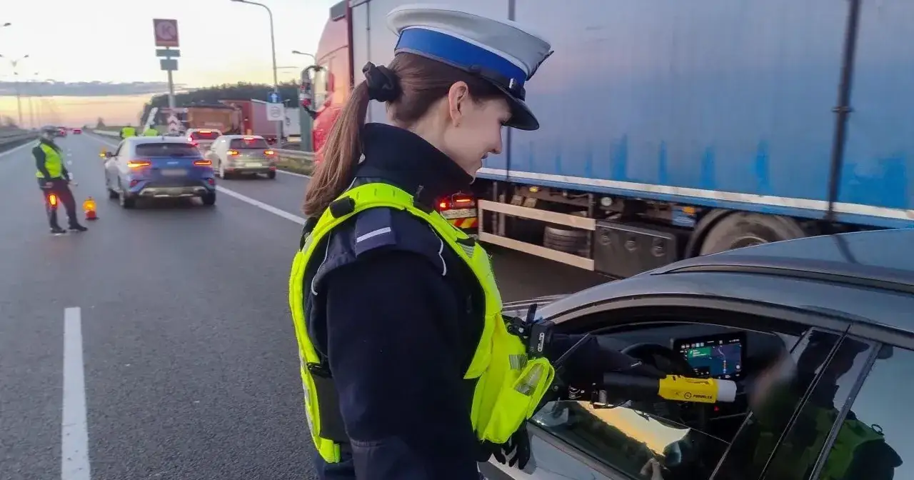 Policjantka kontroluje kierowcę na drodze, sprawdzając trzeźwość. W Czechach limit alkoholu jest niski, więc takie kontrole są ważne.