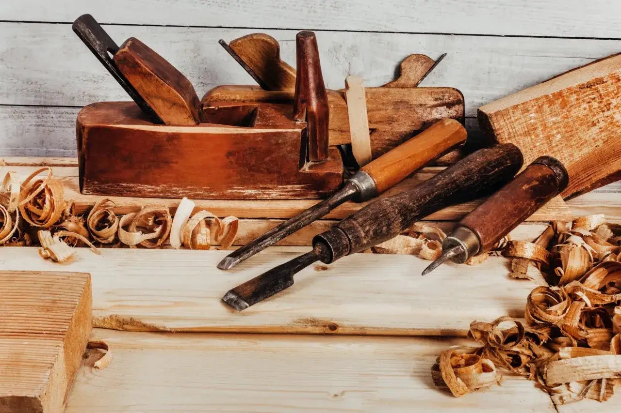 Ensemble d'un vieil outil &eacute;b&eacute;niste, des ciseaux et des copeaux de bois sur une surface en bois.