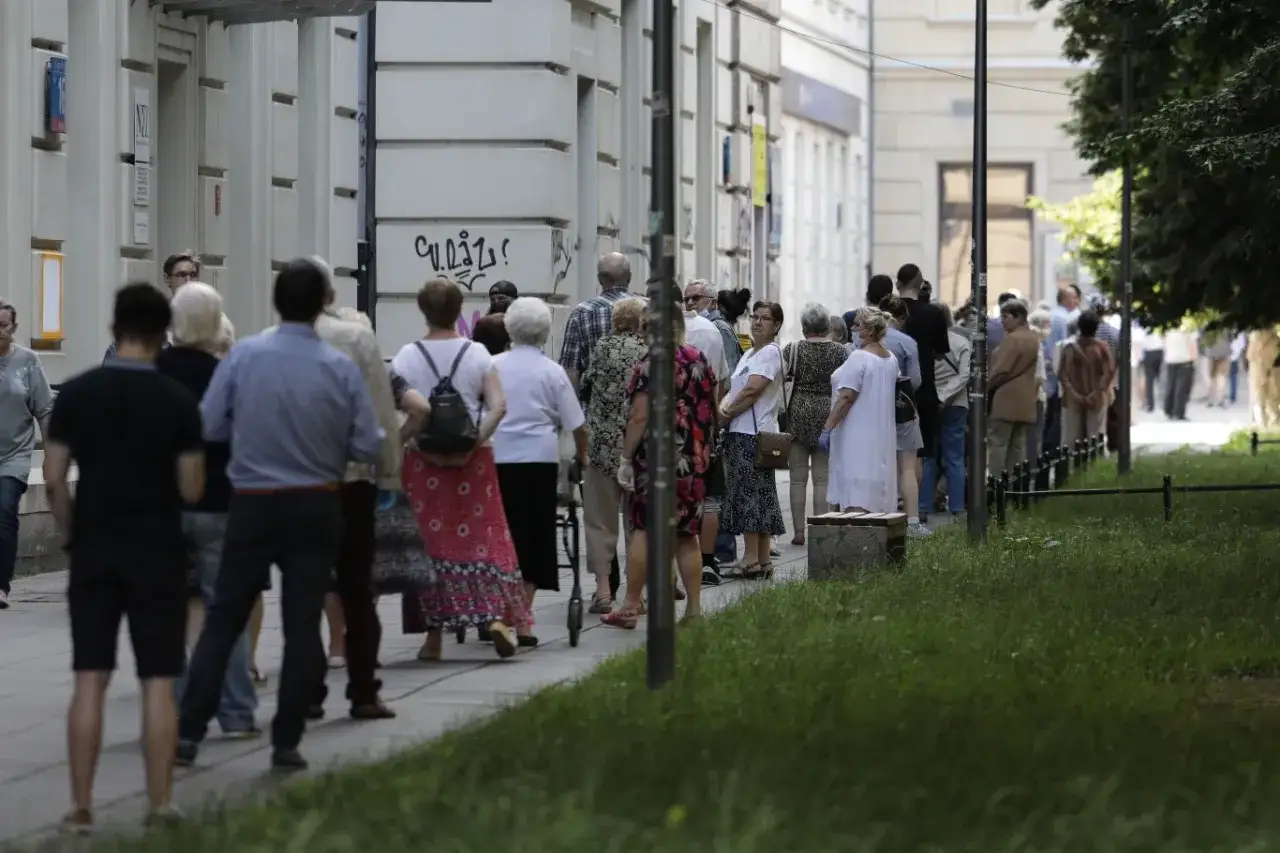 Długa kolejka ludzi czeka przed budynkiem. Czy zdążą oddać głos przed zamknięciem lokalu wyborczego?