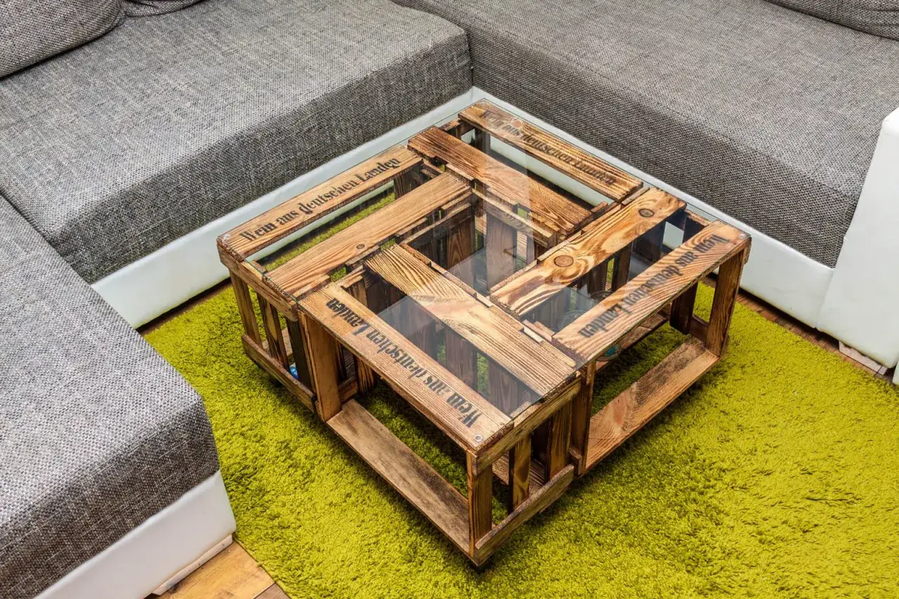 Ein einzigartiger couchtisch selber bauen aus Holzkisten mit Glasplatte, der rustikalen Charme in jedes Wohnzimmer bringt.