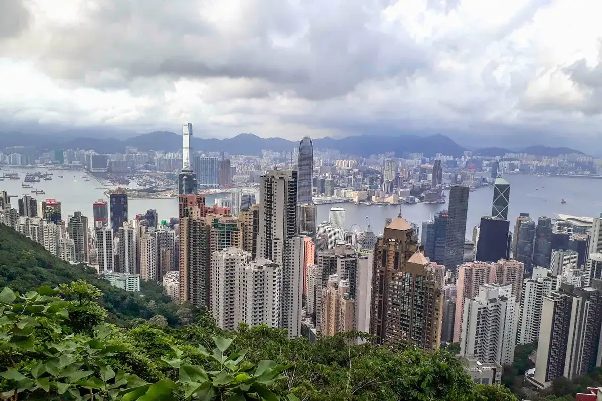 Blick auf die Skyline von Hongkong mit Bergen im Hintergrund. Ein perfekter Ausblick f&uuml;r den Hongkong Urlaub.