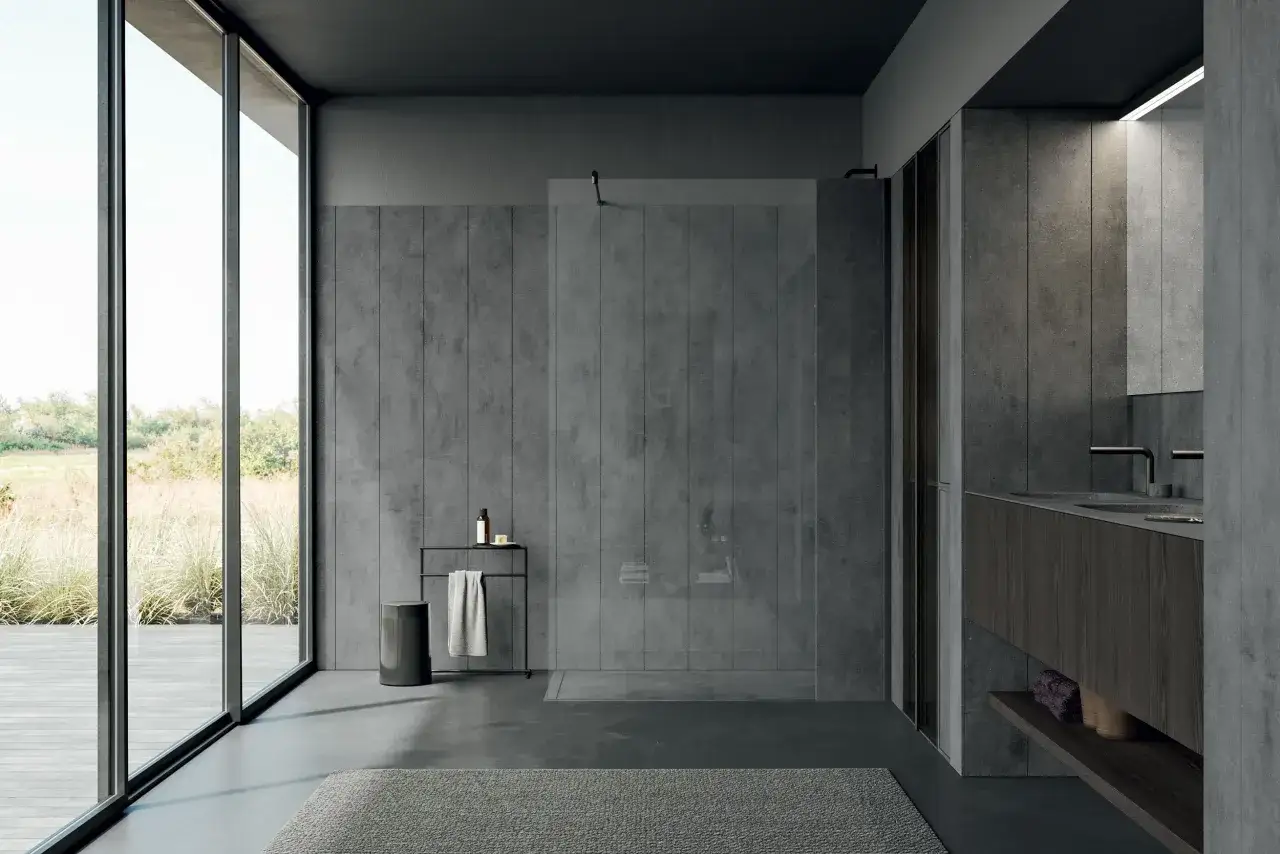 Bagno moderno con pareti in gres effetto cemento e lavabo in **materiale Corian**. Ampie vetrate affacciano su un giardino rigoglioso.