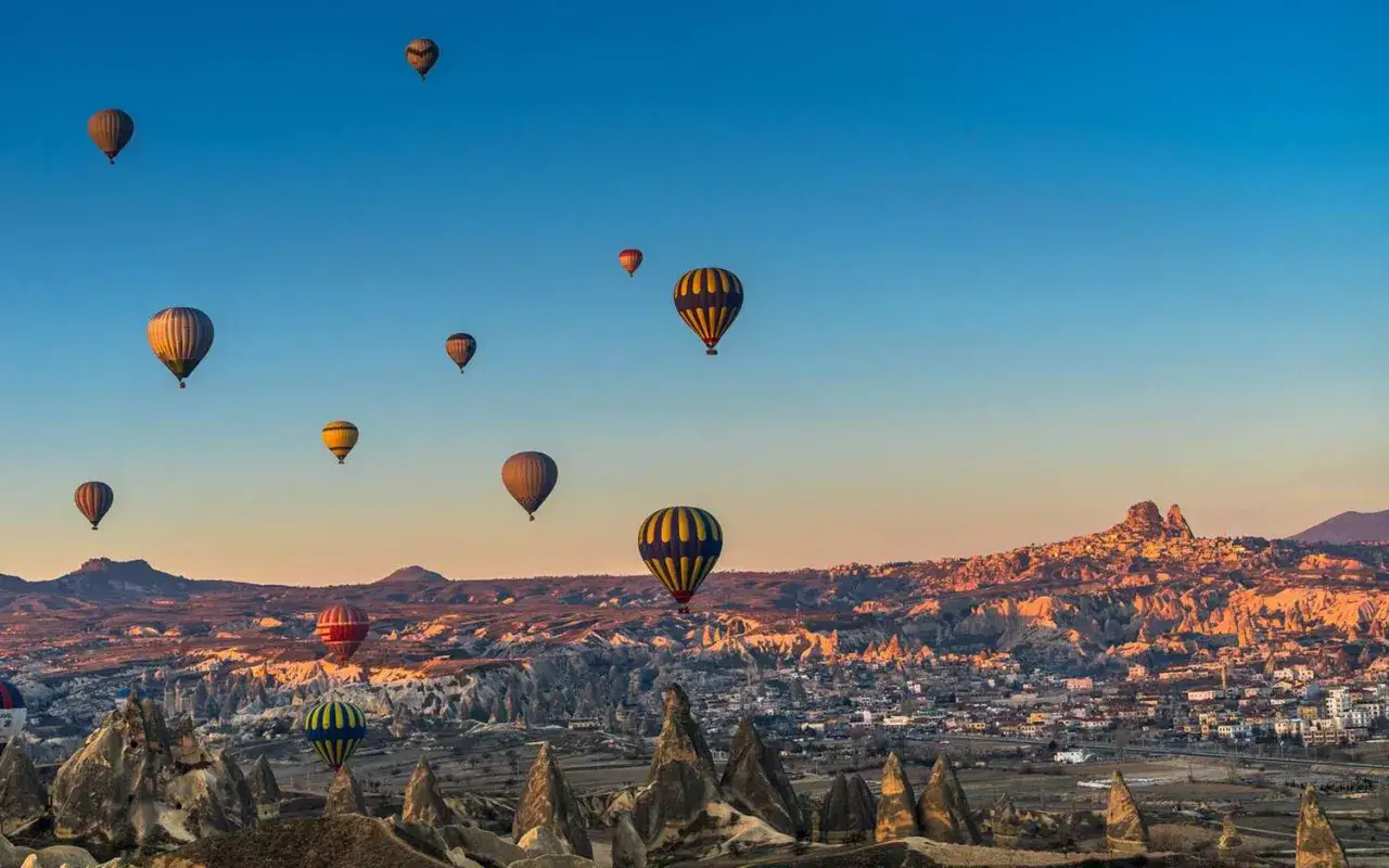 Luftballonger sv&auml;var &ouml;ver det unika landskapet i Kappadokien, Turkiet, vid soluppg&aring;ngen.