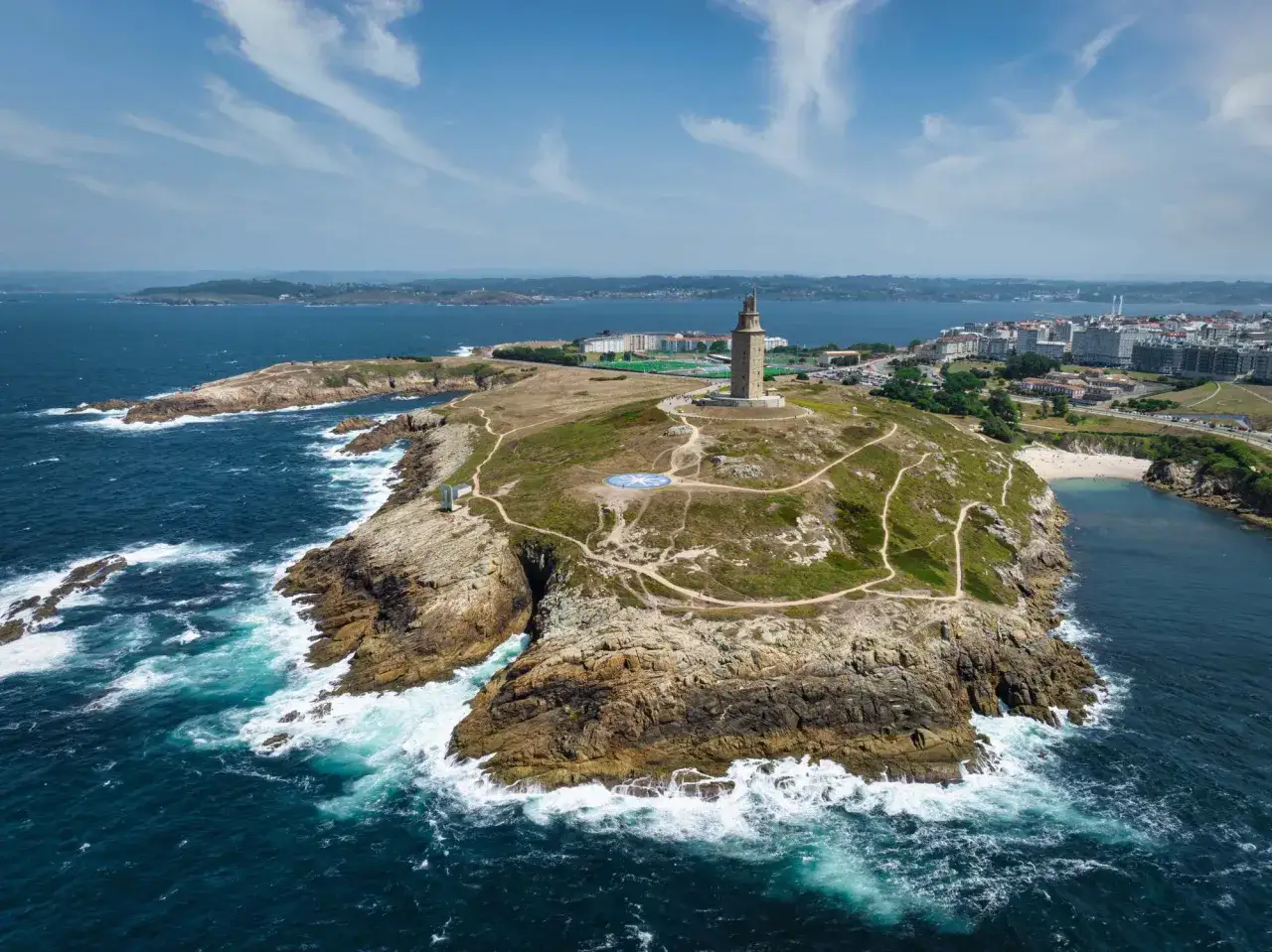 Torre de Hércules y costa rocosa, preludio de las 10 mejores playas de A Coruña.