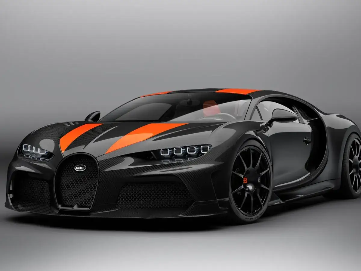 Czarny Bugatti Chiron Super Sport z pomarańczowymi pasami na masce i dachu, prezentujący swoją sportową sylwetkę.