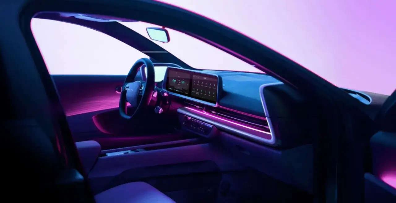 Wnętrze Hyundai Ioniq 6 z futurystycznym ambientowym oświetleniem w odcieniach fioletu i różu.