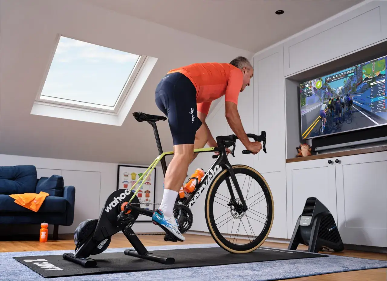Man cycling indoors on a Wahoo Kickr Core 2 trainer, racing virtually on Zwift.