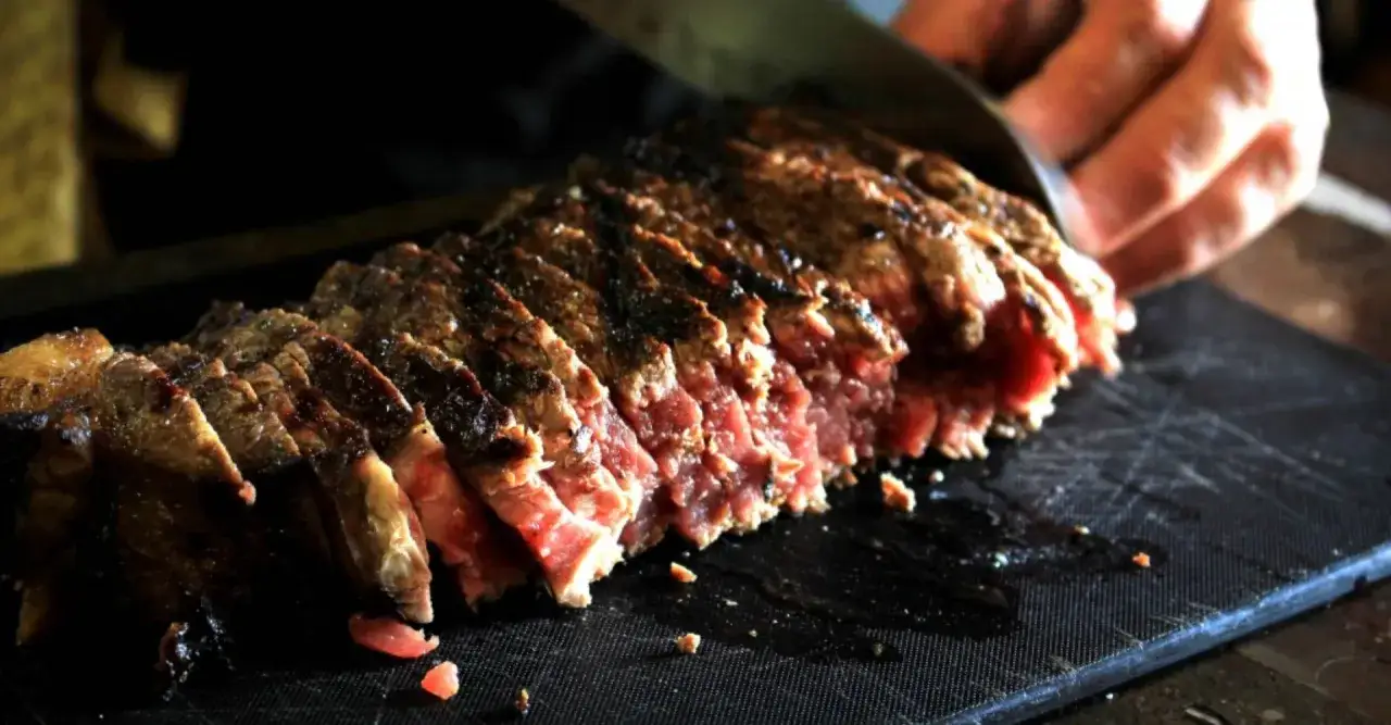 Une belle tagliata de boeuf, tranchée et prête à être dégustée, avec une cuisson rosée parfaite.